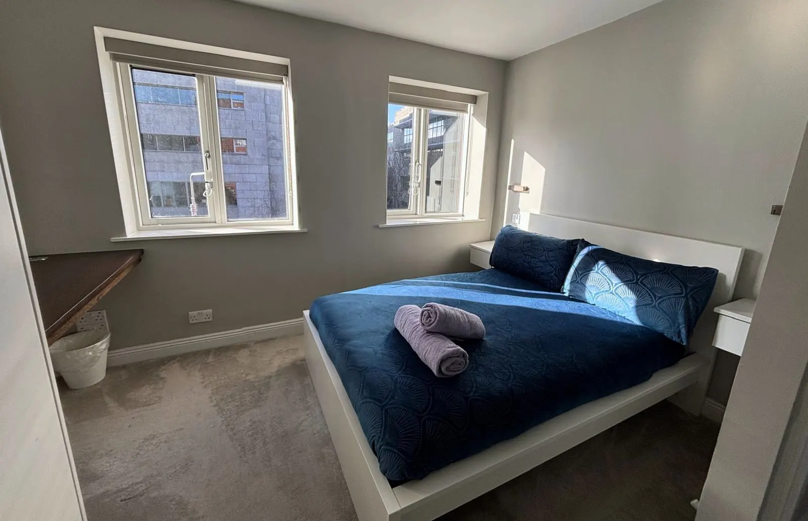 Bedroom of a short let apartment made up with fresh towels between guests