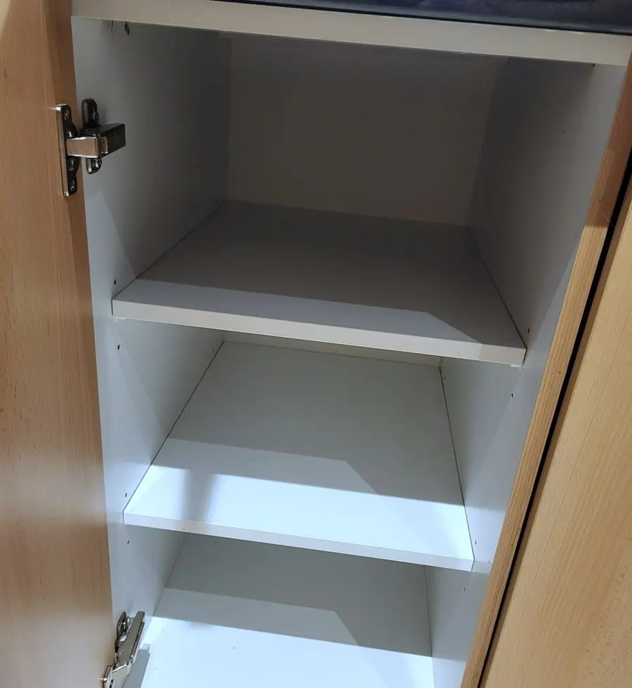 Inside a kitchen cupboard, cleared and wiped