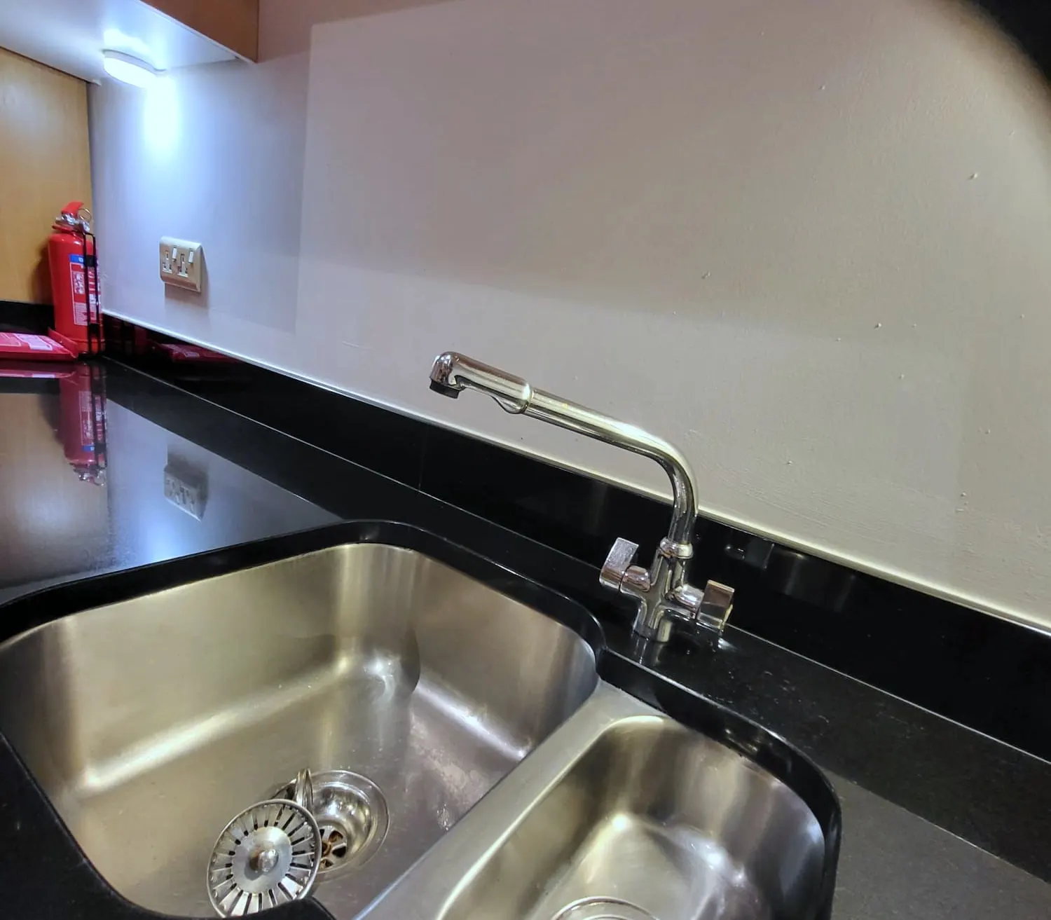 Stainless steel sink and worktop in a workplace kitchen after cleaning